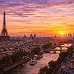 Paris skyline at sunset with Eiffel Tower and River Seine glowing in golden light